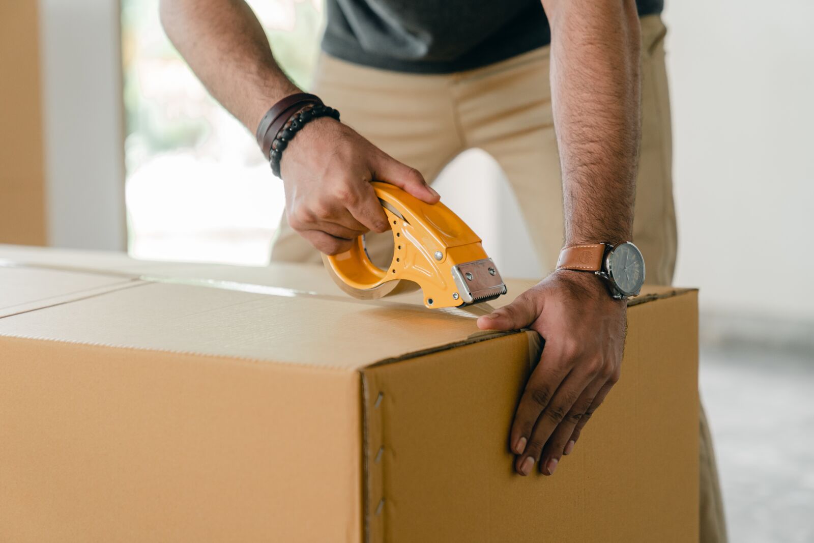 man taping up boxes