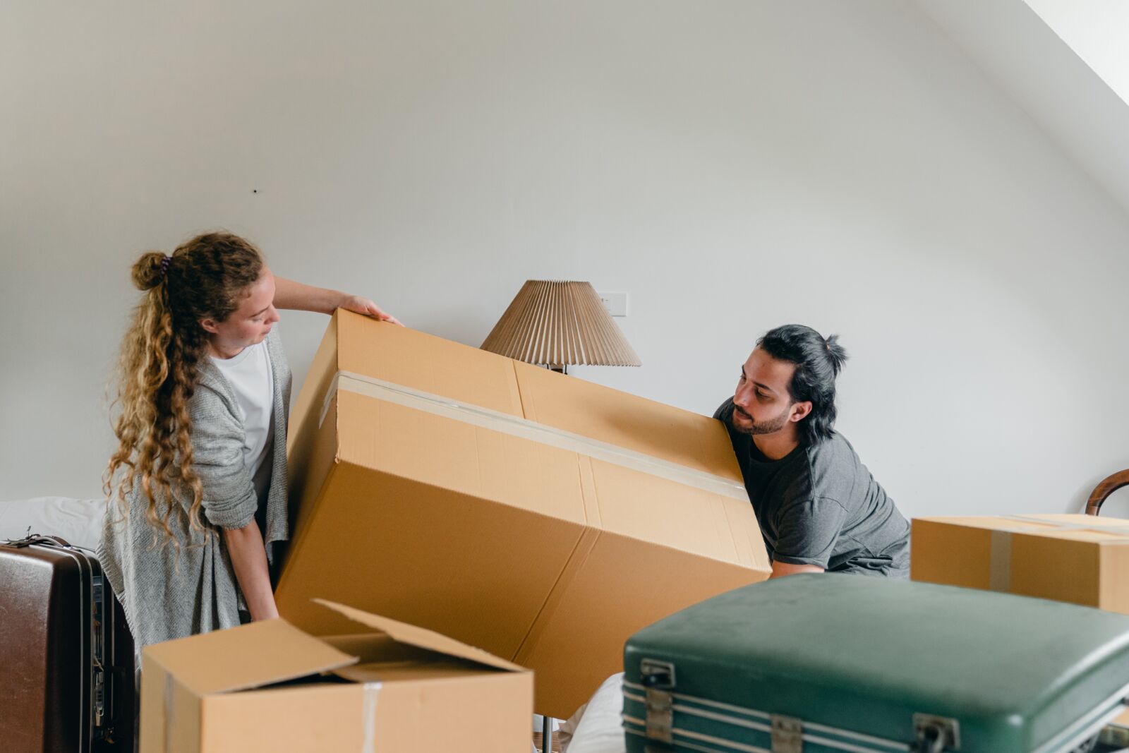 pexels-ketut-subiyanto-4246009 two people picking up a large cardboard box
