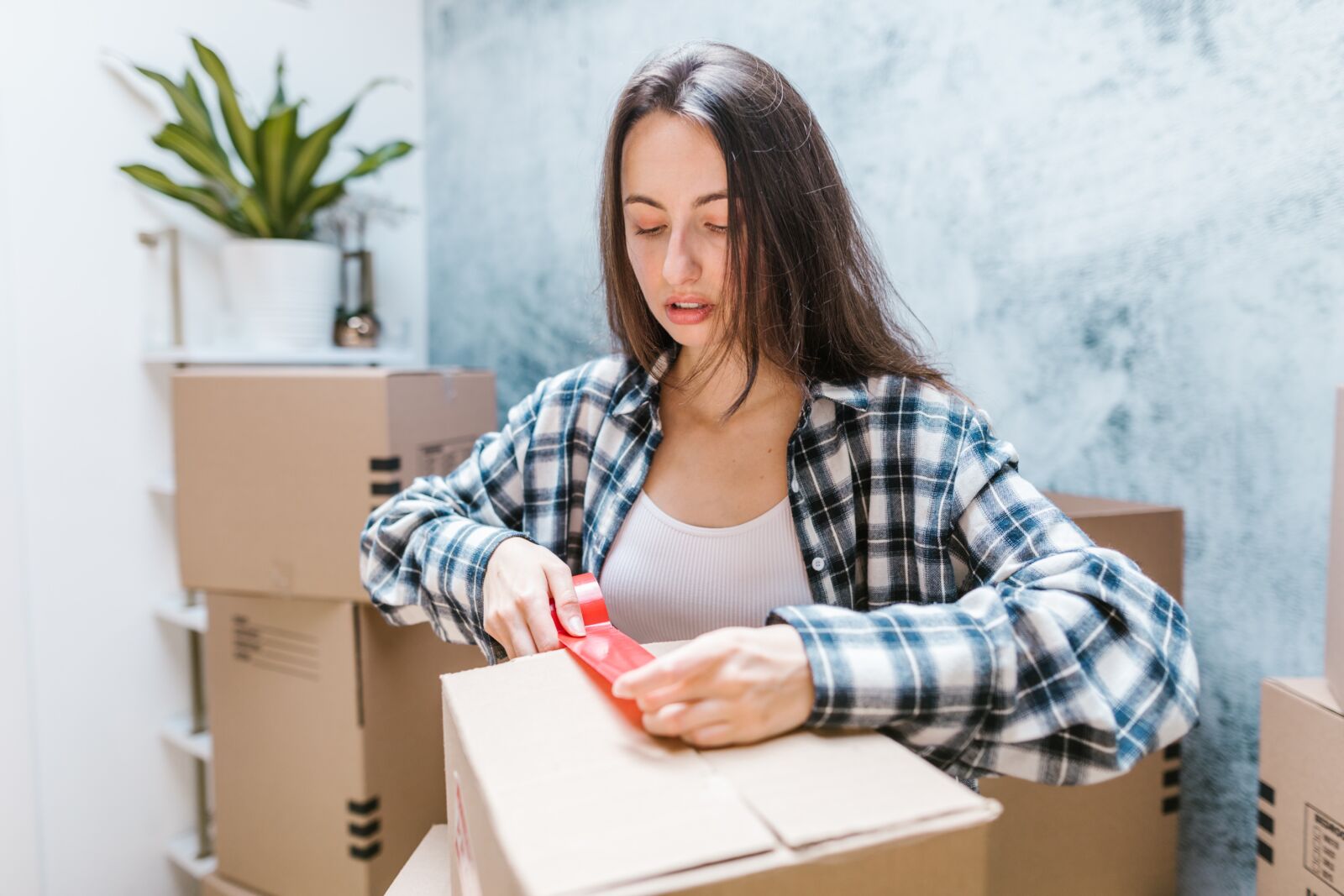 pexels-rodnae-productions-7464468 woman taping up a cardboard box