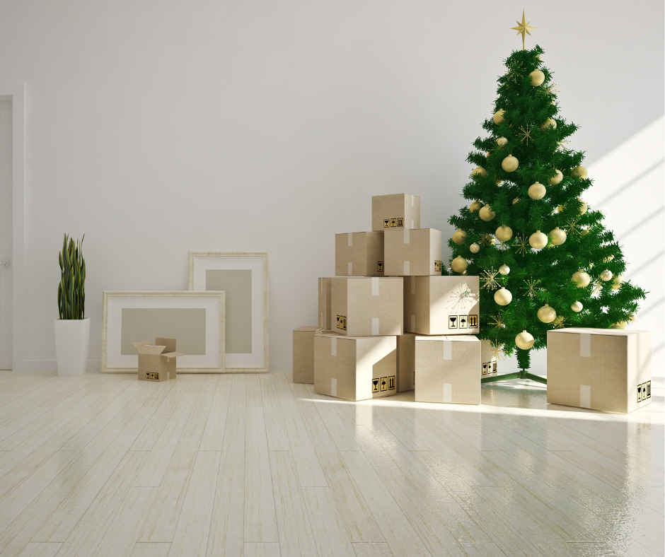 christmas tree with gold baubles next to cardboard boxes