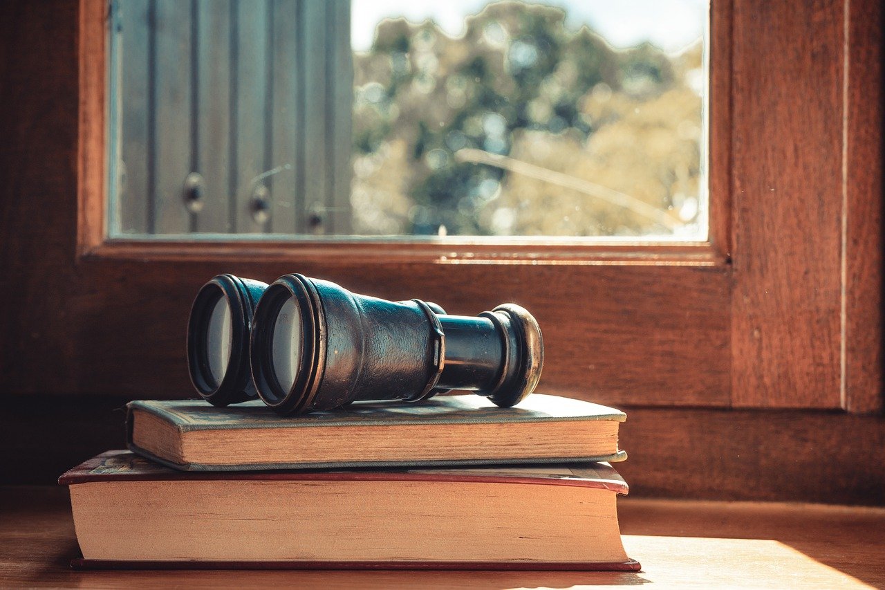 binoculars on some books by a window